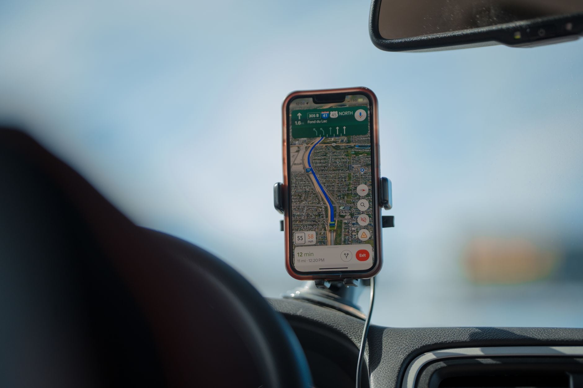 Smartphone med navigationskarta i bilmontering visar rutt, körtid på 12 minuter och trafikväg framåt