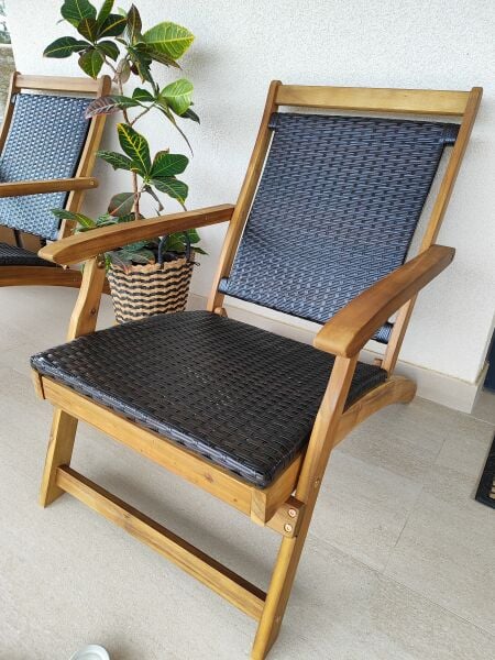 Silla de madera con respaldo y asiento tapizado en azul marino, junto a planta en maceta