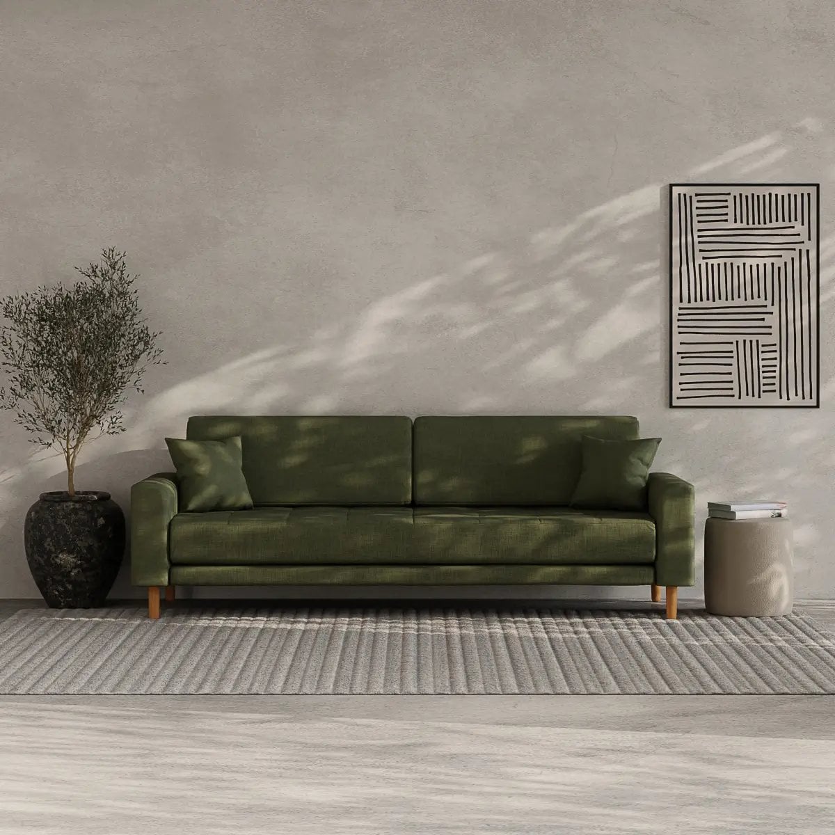 Canapé vert sauge dans un intérieur minimaliste avec mur gris ciment et tapis gris rayé