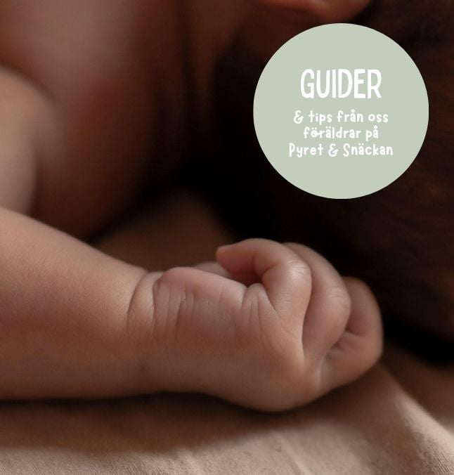 Närbild på babyhands mot neutral bakgrund med grön cirkel med texten "GUIDER"