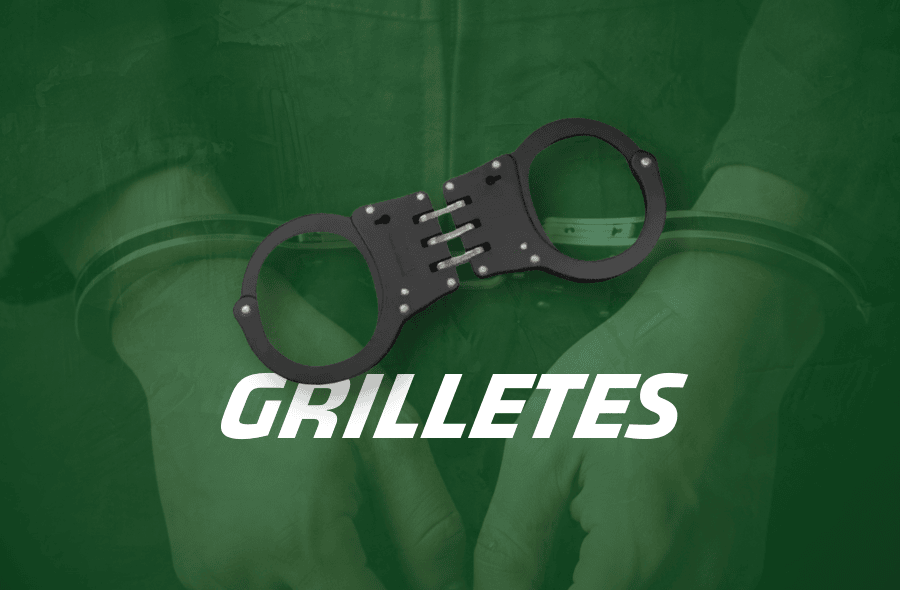 Grilletes negros de metal con correas sobre fondo verde