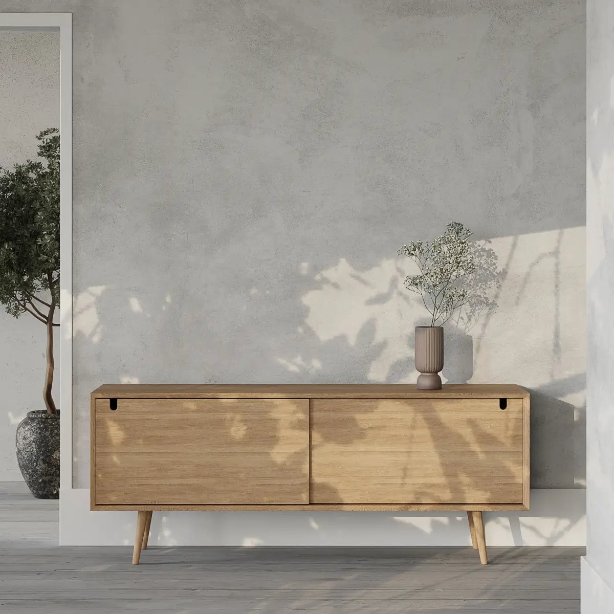 Buffet bas en bois naturel avec deux portes sous un vase gris et mur gris clair texturisé