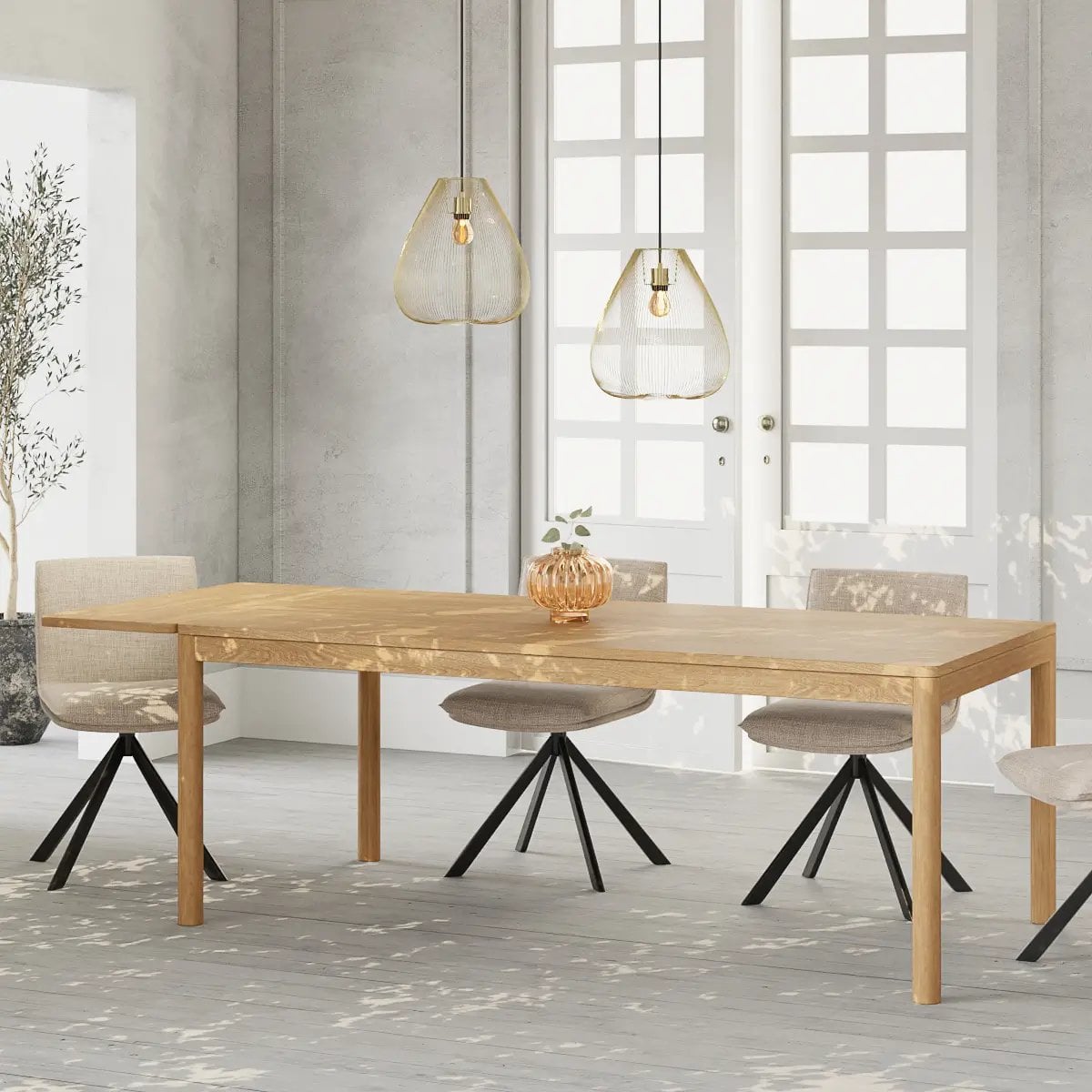 Table à manger en bois clair avec chaises grises et noires sous deux lampes suspendues modernes en verre